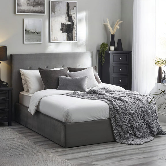 Modern bedroom with gray upholstered bed, nightstands, and abstract art on the wall.