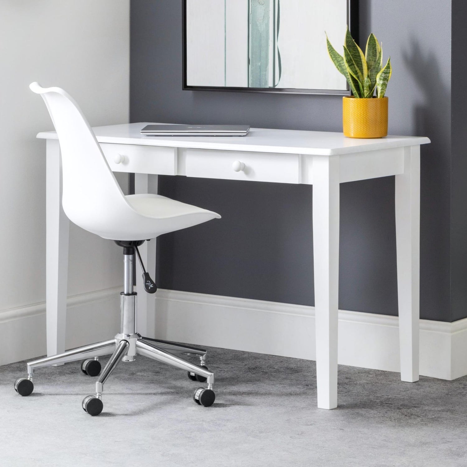 White desk with a chair and plant against a gray wall