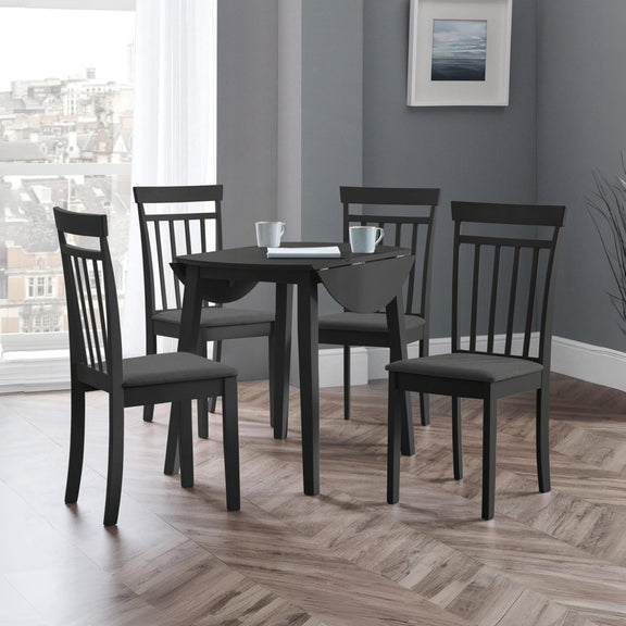 Dining room with a black dining table and chairs in a room with a window and framed picture on the wall.