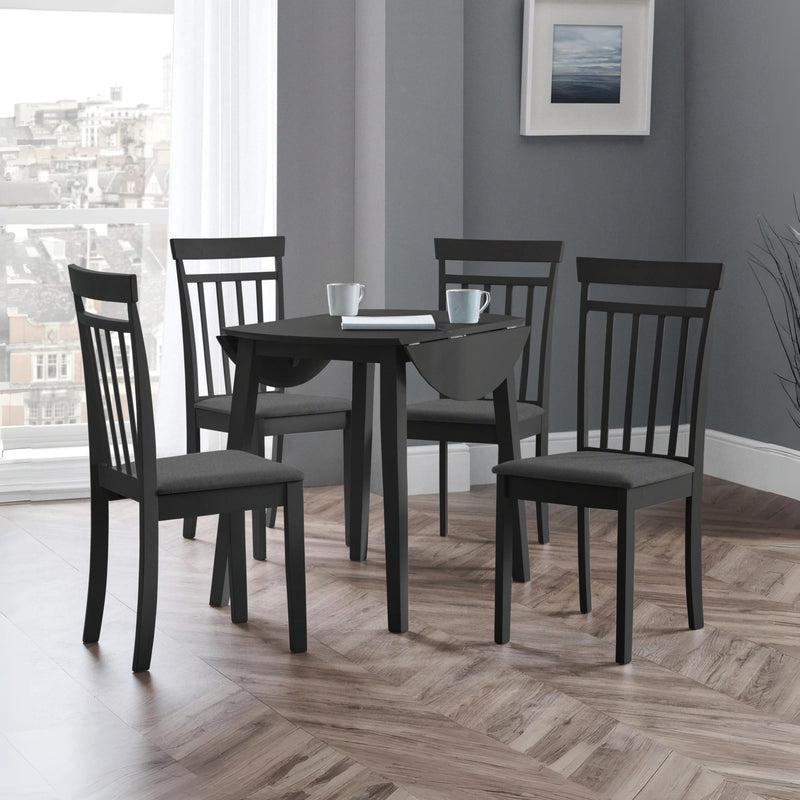 Dining room with a black dining table and chairs in a room with a window and framed picture on the wall.