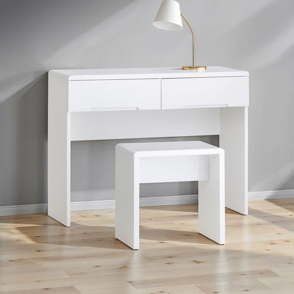 White desk with a matching stool in a room with wooden flooring and gray walls.