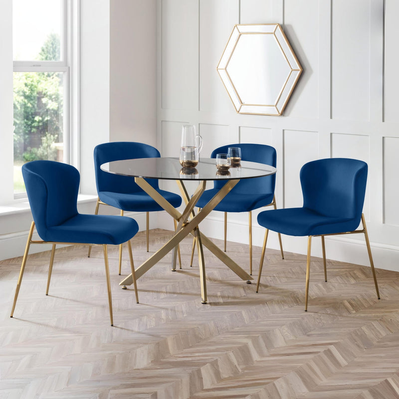 Dining room with blue chairs and a round glass table.
