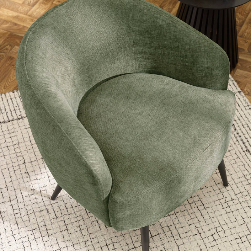 Green armchair on a textured rug with a wooden floor background