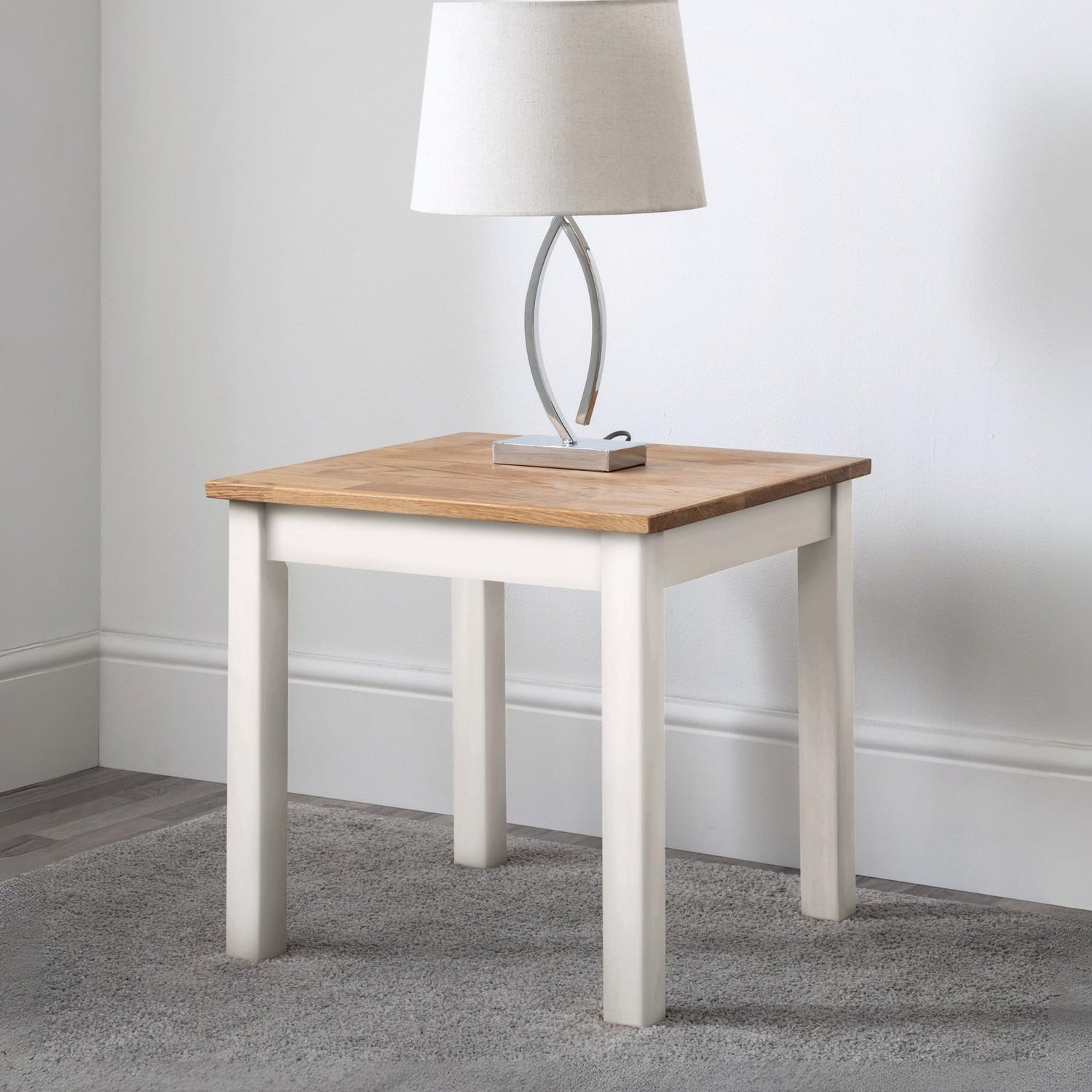 Small wooden side table with a white base against a plain wall.