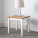 Small wooden side table with a white base against a plain wall.