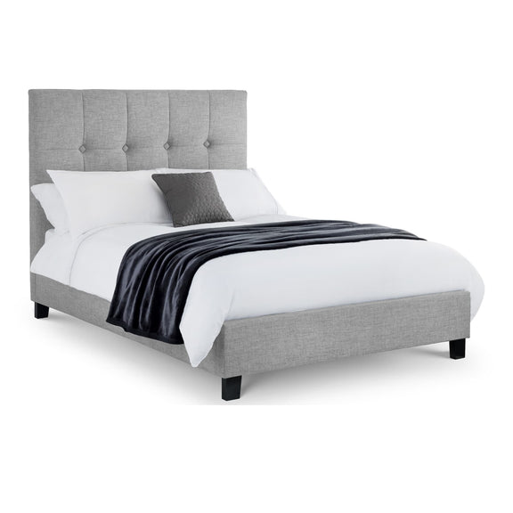 Gray upholstered bed with white bedding and a gray blanket on a white background
