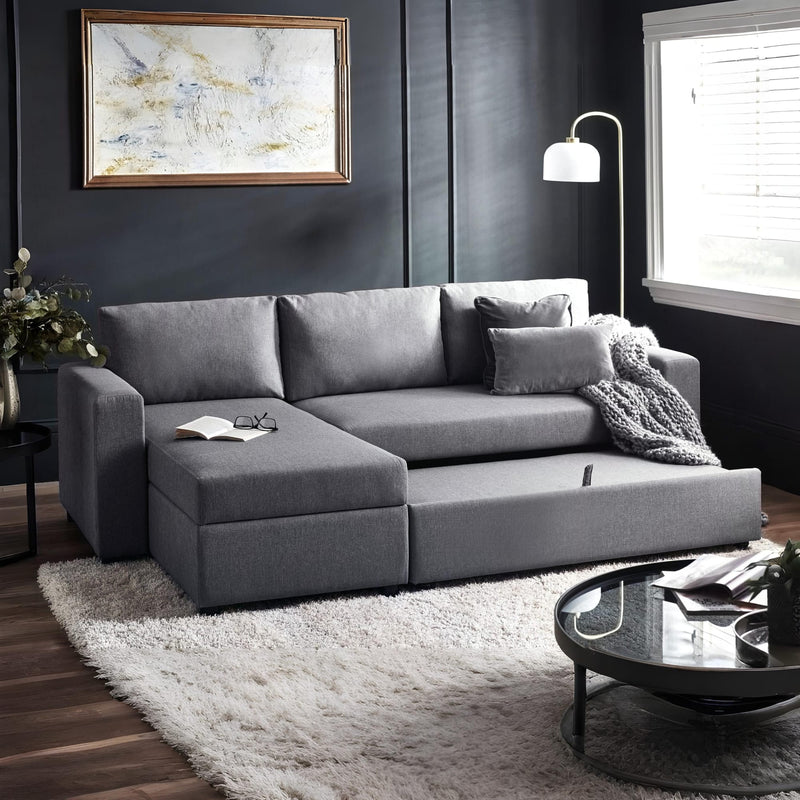 Gray sectional sofa in a living room with a rug, coffee table, and decorative items.
