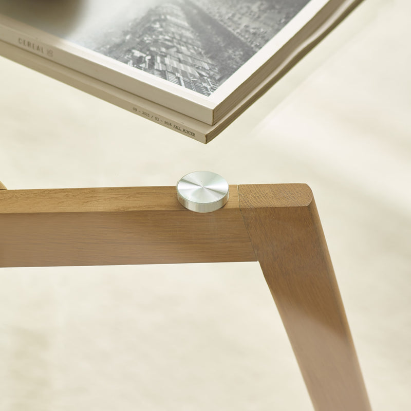 Wooden table leg with a metal knob on a light background