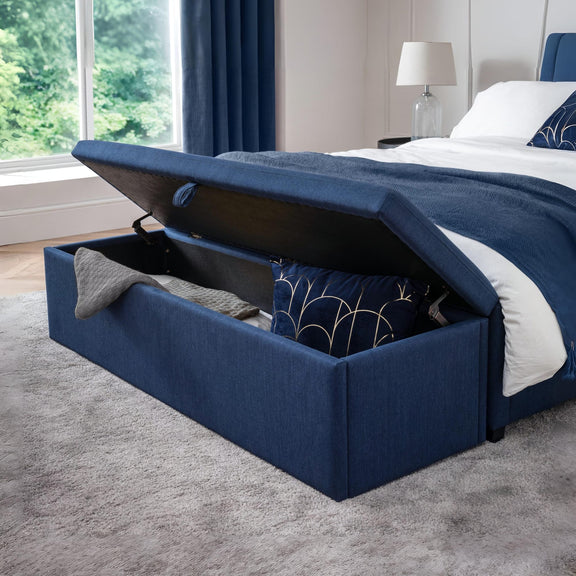 Navy blue storage bed with open lid in a bedroom setting.
