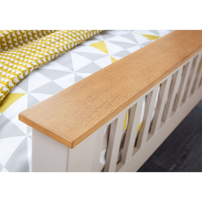 Wooden bench with a white cushion and yellow checkered blanket on a white background