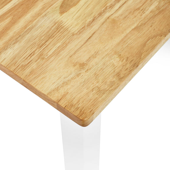 Close-up of a wooden table corner with a white base on a white background