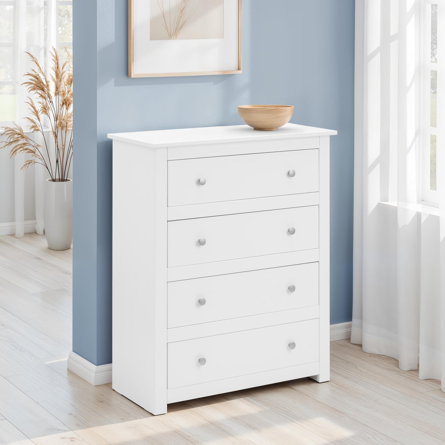 White dresser with four drawers against a blue wall in a room with natural light.