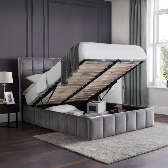 Gray upholstered bed with storage compartment in a bedroom setting