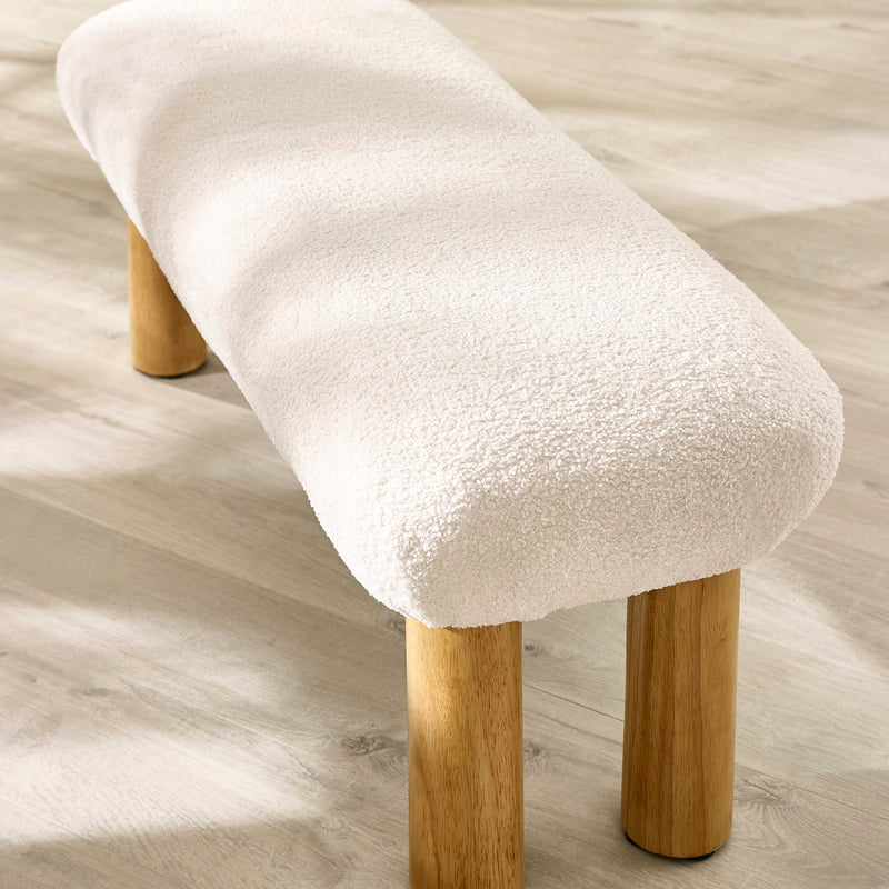 Stool with white cushioned seat and wooden legs on a light wood floor