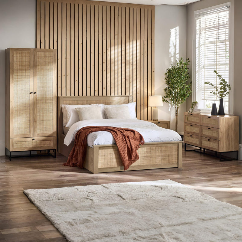 Wooden bedroom set with bed, wardrobe, and dresser in a well-lit room.