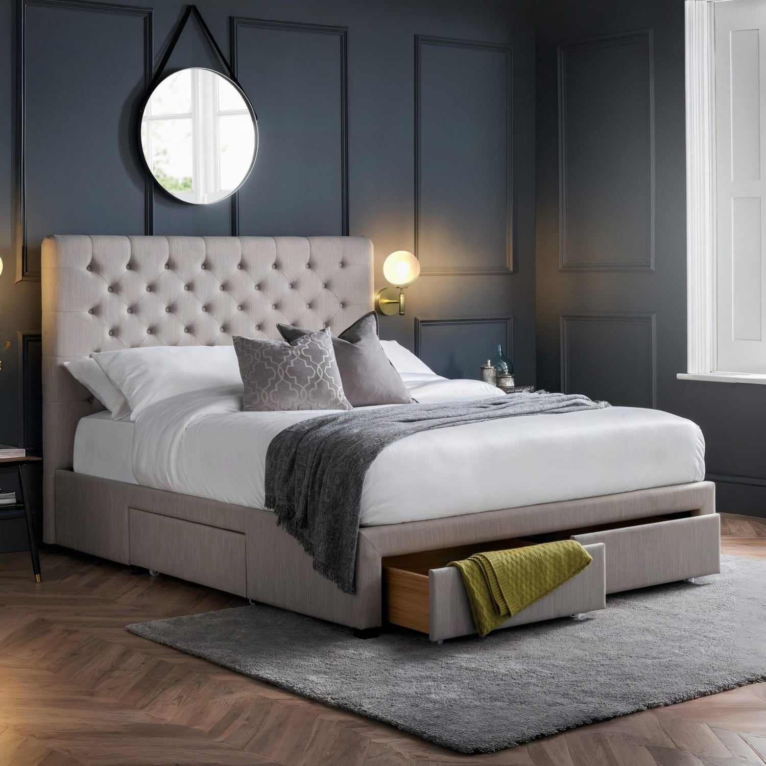 Modern bedroom with a gray upholstered bed and open drawer.
