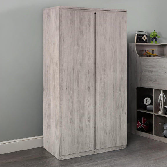 Wooden wardrobe against a gray wall with a shelf containing toys and decor items.