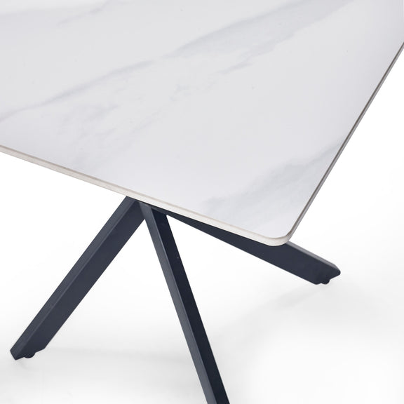 Table with a white surface and black metal legs on a white background