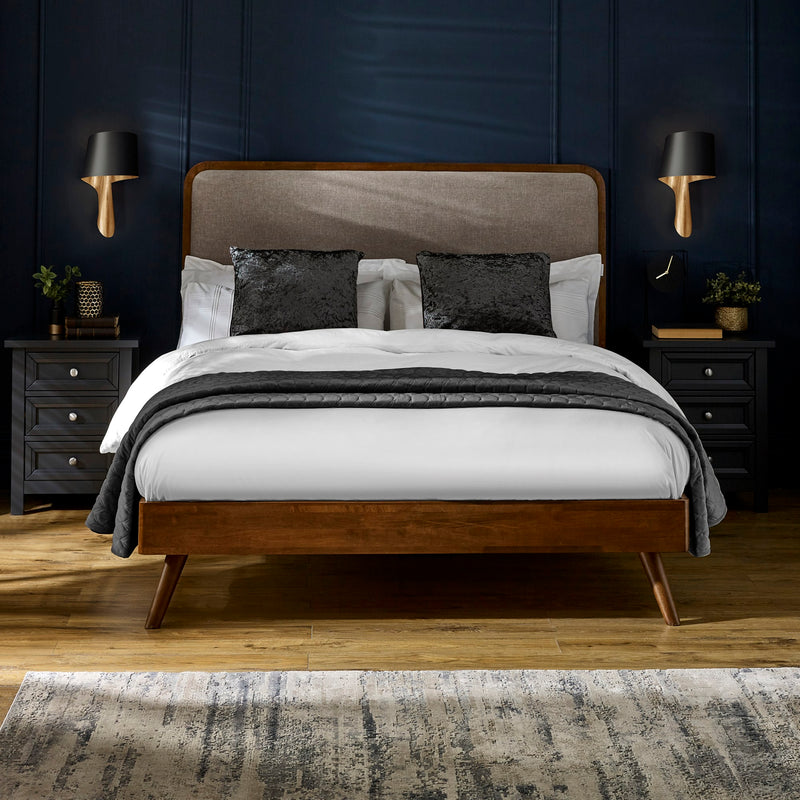 Bedroom with a wooden bed frame, gray headboard, and white bedding.