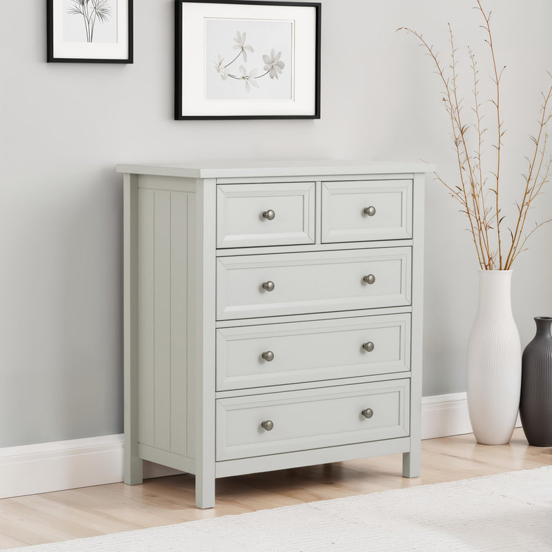 Gray dresser with multiple drawers in a room with a light gray wall and decorative elements.