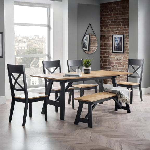 Dining room with wooden table and chairs against a brick wall.