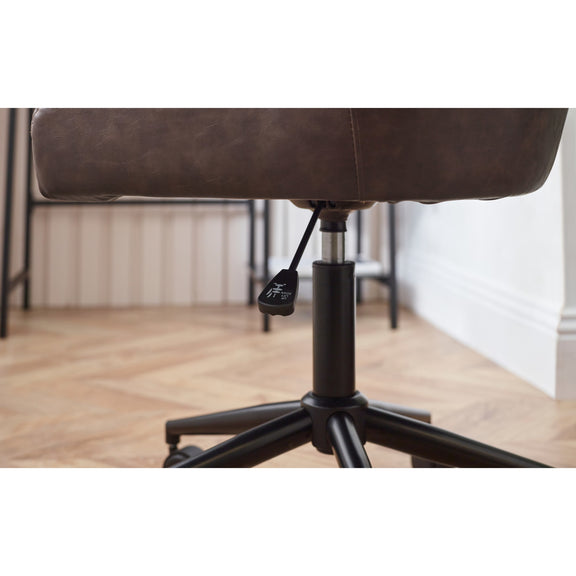 Brown office chair with black base on a wooden floor.