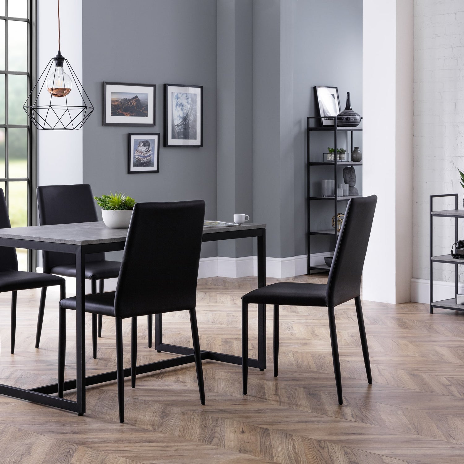 Dining room with a table and chairs against a gray wall.
