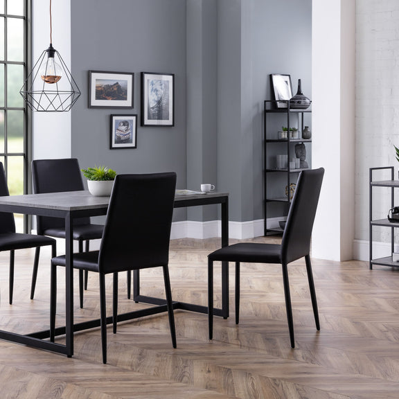 Dining room with a table and chairs against a gray wall.