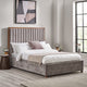 Gray upholstered bed with wooden headboard in a bedroom setting.