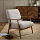 Gray upholstered armchair with wooden frame in a room setting.