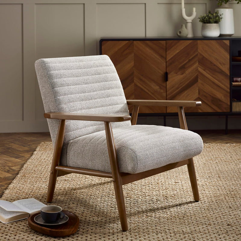 Gray upholstered armchair with wooden frame in a room setting.