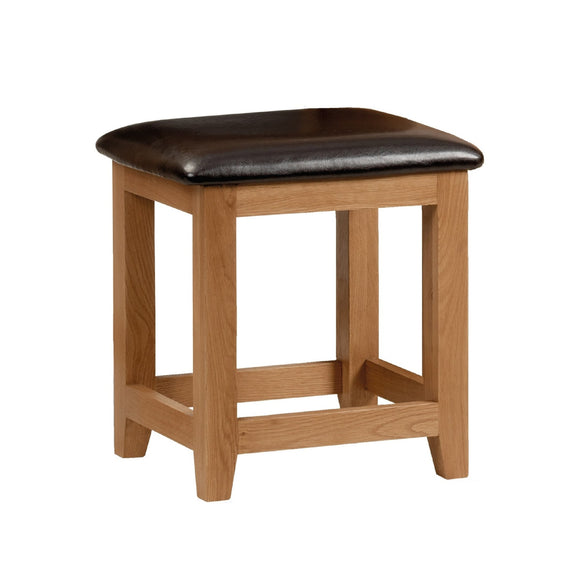 Wooden stool with a black cushioned seat on a white background