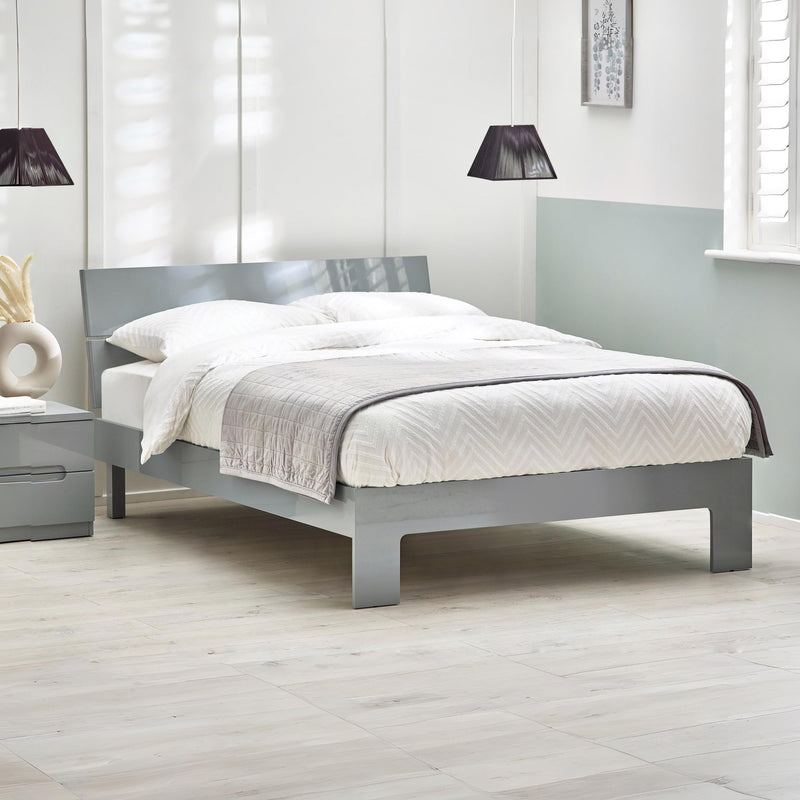 Gray bed frame with white bedding in a modern bedroom setting.