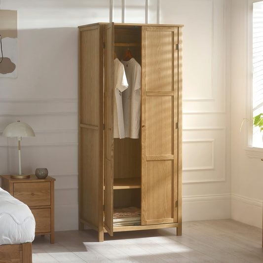 Wooden wardrobe with clothes inside in a bedroom setting