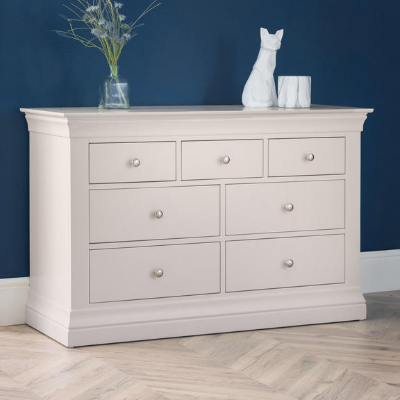 Light gray dresser with six drawers against a blue wall