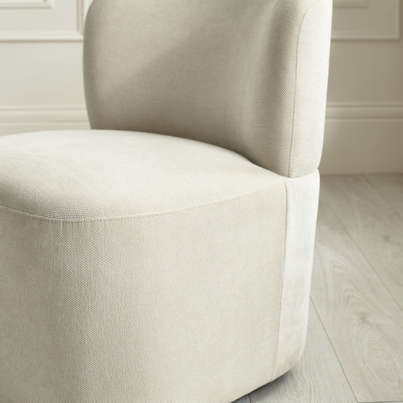 Close-up of a beige upholstered chair in a neutral setting