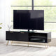 Black TV stand with a flat-screen TV in a room with large windows.