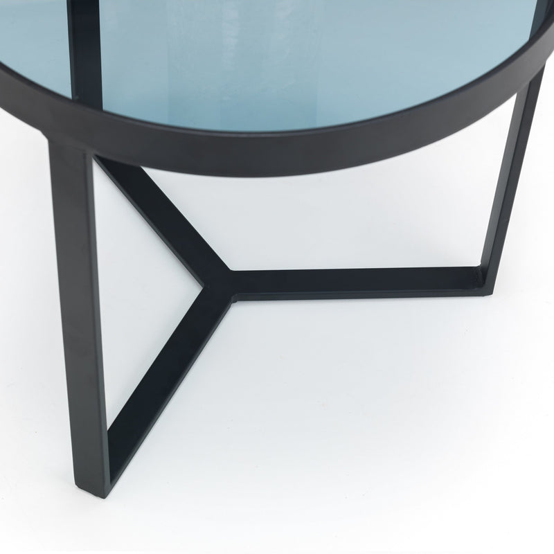 Close-up of a round glass table with a black metal frame on a white background