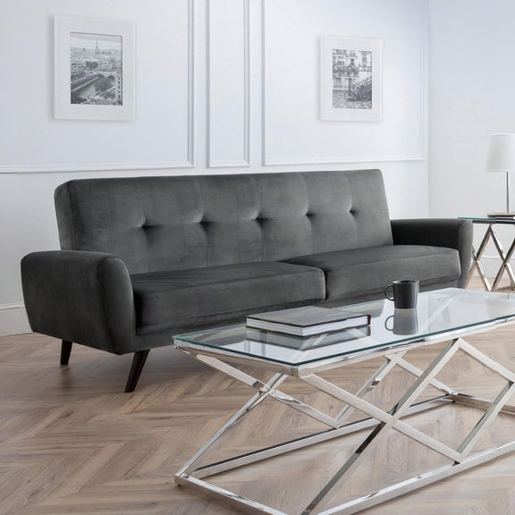 Gray sofa in a living room with a glass coffee table and decorative elements.