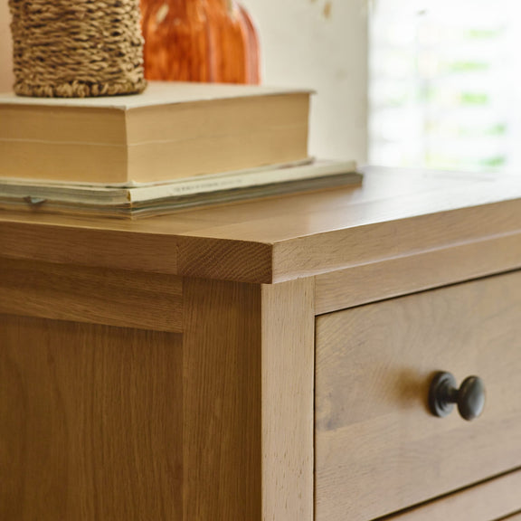 Wooden dresser with a drawer and books on top