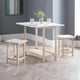 Dining table set with two stools in a room with gray walls and wooden flooring.