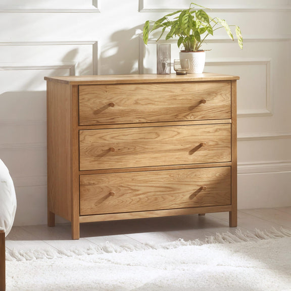 Wooden dresser with three drawers in a bedroom setting