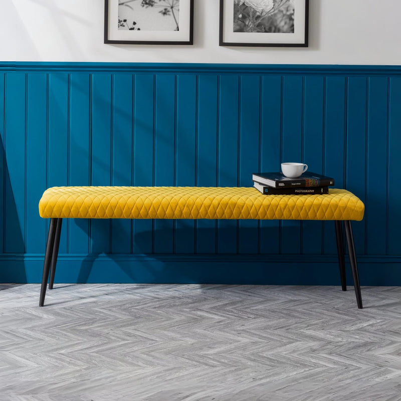 Yellow bench against a blue paneled wall with decorative elements.