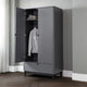 Gray wardrobe with open door showing clothes inside against a gray wall.