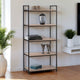 Bookshelf with decorative items in a room with plants and a window.