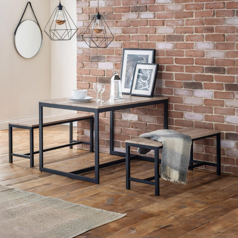 Dining area with a table, chairs, and decor against a brick wall.