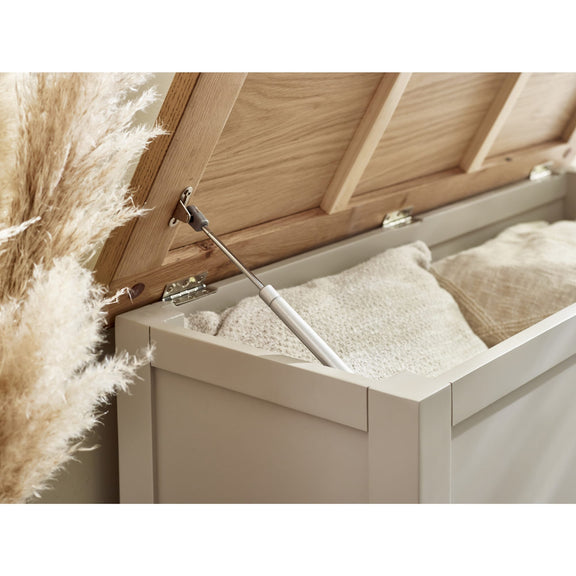 Wooden storage box with a white interior, partially open, revealing some items.
