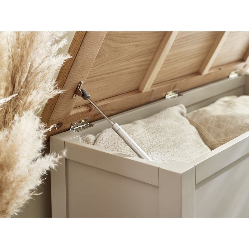 Wooden storage box with a white interior, partially open, revealing some items.
