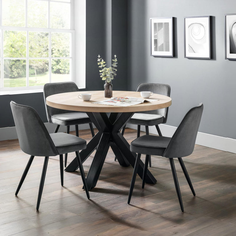Dining room with round wooden table and gray chairs against a gray wall.