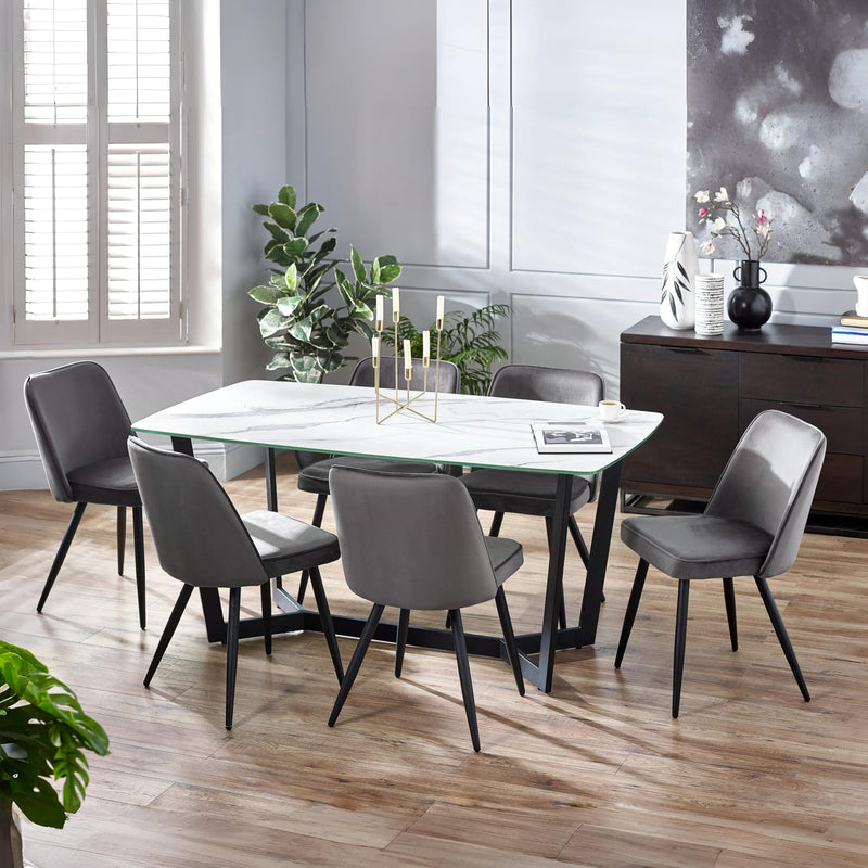Dining room with a marble table and gray chairs in a modern setting.